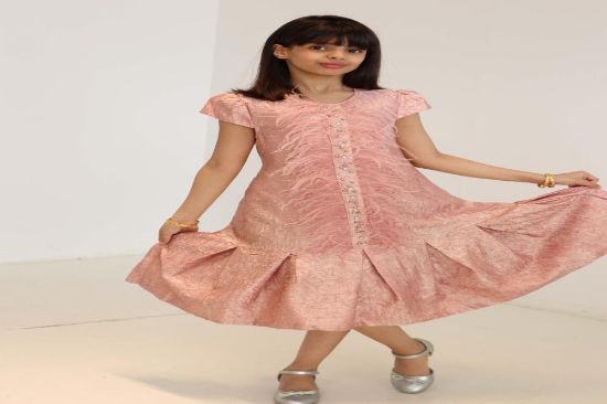 صورة فستان لحمي مع الؤلؤ والريش في نص الفستان